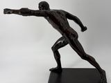 bronze statue of a man holding a tennis racquet on a black base