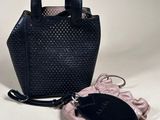the small black bag is next to the small pink purse