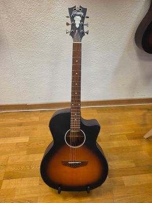 an acoustic guitar sitting on a hard wood floor next to a wall