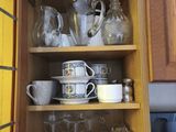 a cabinet with a lot of cups and mugs on it