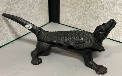 une figurine représentant un chien noir, posée sur une étagère en verre