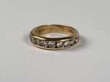gros plan d'une bague en or avec des diamants sur une surface blanche