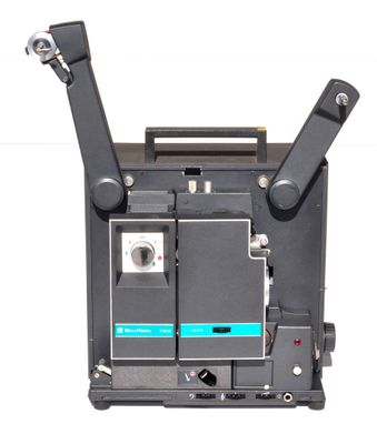 un vieux projecteur de cinéma posé sur une surface blanche