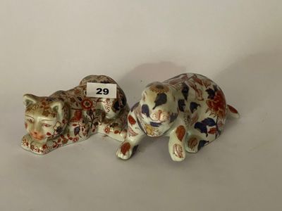 deux figurines de chats assis l'une à côté de l'autre sur une table