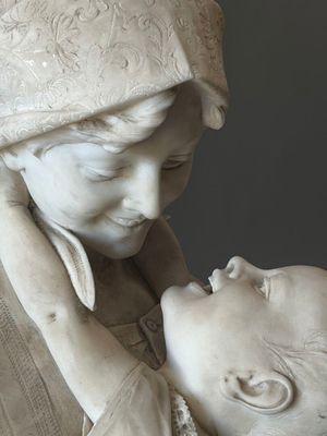 une statue de femme tenant un bébé dans ses bras
