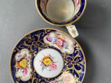 a close up of a cup and saucer on a table