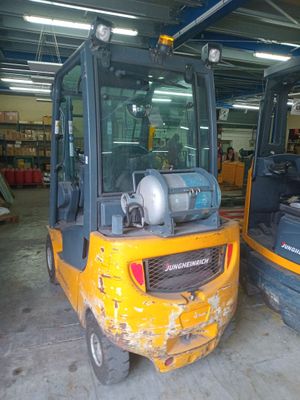 two yellow forklifts parked in a warehouse