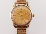 a close up of a gold wrist watch on a white surface