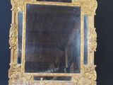a mirror on a small wooden stand against a black wall