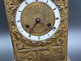 a gold clock sitting on top of a table