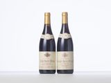 two bottles of wine sitting on top of a table next to each other