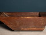an old wooden box sitting on top of a floor next to a blue wall