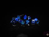 quelques cristaux bleus posés sur une surface noire