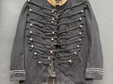 une vieille veste militaire accrochée au mur à un cintre en bois
