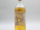 une image représentant une bouteille en verre contenant un liquide jaune