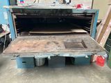 an open oven sitting in the middle of a room