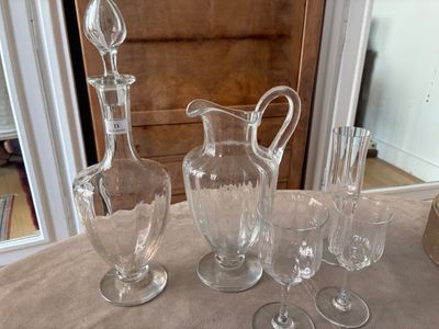 une table sur laquelle se trouvent de nombreux objets en verre