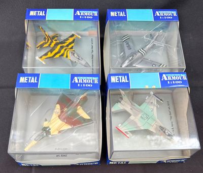 quatre maquettes d'avions en plastique dans leurs boîtes, posées sur une surface noire
