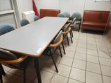 a long table with chairs and a bench in a room