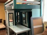 un lit superposé avec un bureau en dessous, dans une chambre