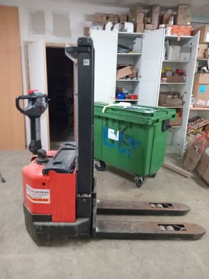 un chariot élévateur garé dans un garage avec d'autres cartons