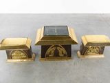 four pieces of brass and glass on a concrete surface