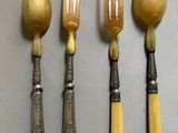 quatre cuillères et une fourchette sont alignées sur une table
