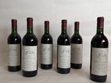 six bottles of wine are lined up in a row on a table