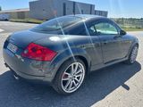 a picture of a black sports car parked in a parking lot