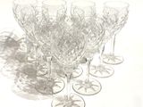 many wine glasses lined up on a white surface