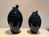 deux vases noirs posés sur une table blanche