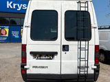 a white van parked in a parking lot with a ladder on the back of the van
