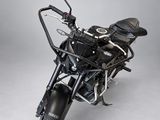 the black motorcycle is parked on the white floor in the studio