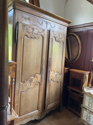 a large wooden armoire in the corner of a room
