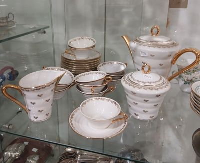 une vitrine en verre contenant de nombreux types de tasses à thé et de soucoupes