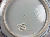 someone is holding a blue and white bowl with a sticker on it