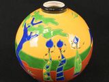 a small vase with a painting on it on a black surface