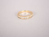a gold ring with diamonds on a white surface