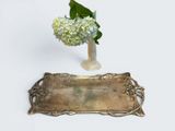 a vase with flowers in it and a silver tray with a flower