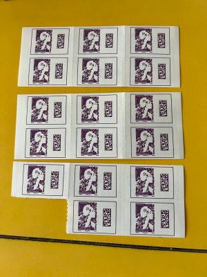 several stamps of different sizes and colors are on a yellow table