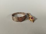 a close up of a gold ring with a red stone on it