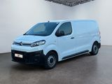 Une camionnette blanche est garée dans une grande pièce.