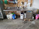 a table with a bunch of bottles on it in a garage
