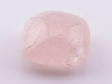un gros plan d'un quartz rose posé sur une surface blanche