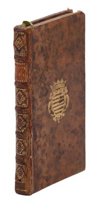 un vieux livre avec un emblème en or sur la couverture