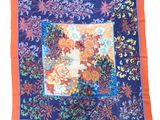 a close up of a blue and orange scarf with flowers