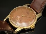 gros plan d'une montre-bracelet avec un bracelet en cuir marron