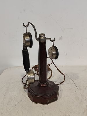 an old fashioned telephone on a table with a cord