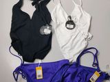 three swimsuits are laid out on a table with tags attached to them