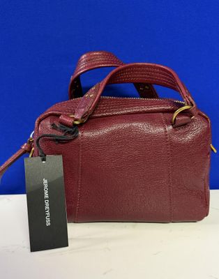 un sac à main rouge muni d'une étiquette, posé sur une table